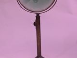 a magnifying glass on a stand on a white background