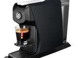 une machine à café noire sur laquelle est posée une tasse de café