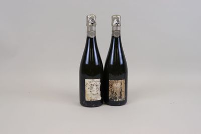 two bottles of wine sitting next to each other on a white surface