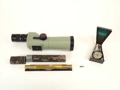 un télescope, une règle et d'autres objets posés sur une surface blanche