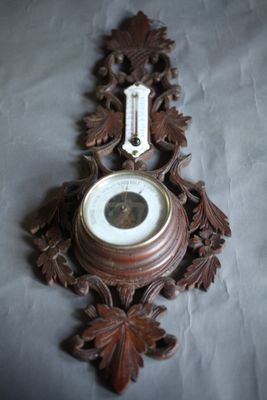 une horloge accrochée au mur, décorée de feuilles