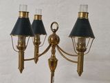 three brass and black lamps on a table with a white background