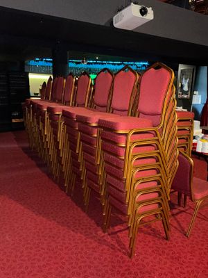 rows of chairs in a room with red carpet and red carpeting