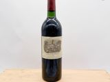 une bouteille de vin posée sur un bloc de bois