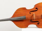 a violin that is sitting on top of a white pedestal