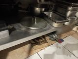 pots and pans are sitting on a metal shelf in a kitchen