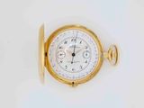 a close up of a gold pocket watch on a white surface