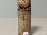 a small vase with a bird on top of it