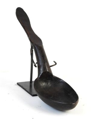 a spoon and spoon rest on a stand on a white surface