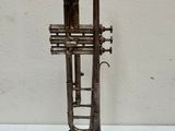 a silver trumpet sitting on top of a table next to a white wall