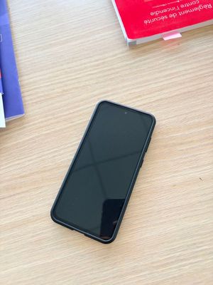 un téléphone portable posé sur une table à côté d'une pile de livres