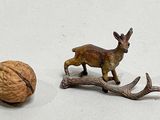 figurines of a deer and a walnut on a white surface