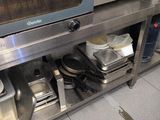 a microwave sitting on top of a metal shelf in a kitchen