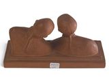 sculpture of a pair of people sitting on a wooden base