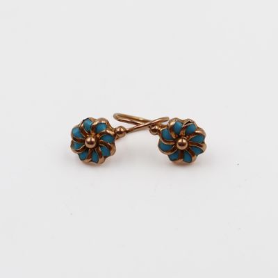 une paire de boucles d'oreilles turquoise et dorées sur fond blanc
