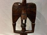statue of a bird on a wooden stand with a white background
