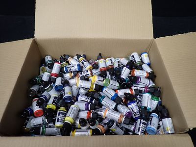 une boîte en carton remplie de flacons de peinture de toutes sortes