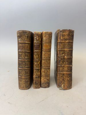 trois vieux livres posés l'un sur l'autre sur une table