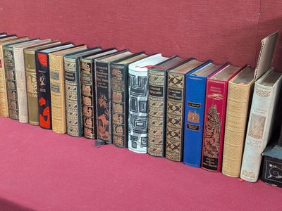de nombreux vieux livres alignés sur un banc rose