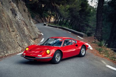 a red sports car driving down a winding road
