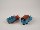two toy trucks sitting next to each other on a white surface