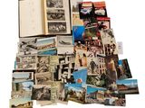 une pile de vieilles photos et de cartes postales posée sur une surface blanche