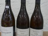 trois bouteilles de vin posées sur une table, l'une à côté de l'autre