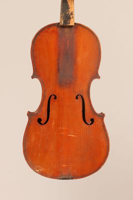 un vieux violon suspendu à une ficelle sur un mur blanc