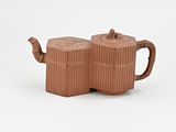 pair of brown ceramic teapots sitting on top of each other