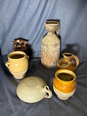many different types of vases sitting on a blue cloth