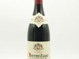 une bouteille de vin rouge posée sur une table blanche