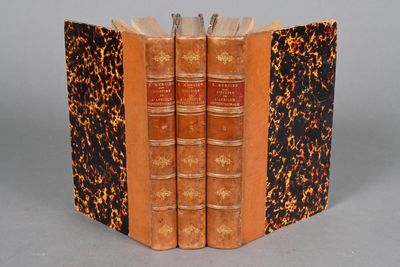 two old books sitting on top of each other on a table