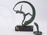 a statue of a man holding a tennis racquet next to a candle