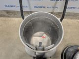 a bucket with a hose attached to it sitting on the floor