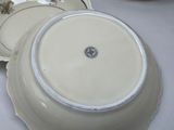 a white plate with a flower on it and a bowl with a flower on it