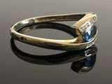 a close up of a gold ring with a blue stone