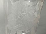 a glass with a design on it sitting on a table