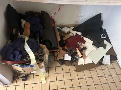 une photo d'une salle de bains en désordre, avec beaucoup d'objets éparpillés sur le sol