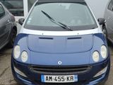 une voiture bleue garée dans un parking à côté d'autres voitures