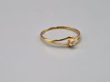gros plan d'une bague en or sur une surface blanche