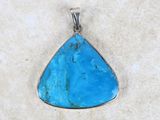 a close up of a blue stone pendant on a white surface