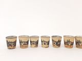 six shot glasses with a picture of a town on them sitting on a table