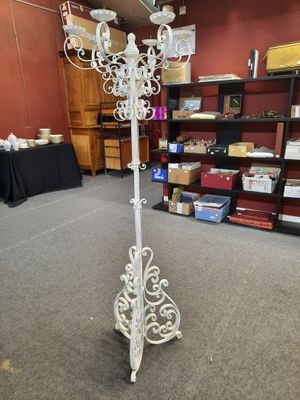 Une image représentant un lustre en fer forgé blanc trône dans une pièce