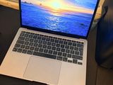 un ordinateur portable posé sur un bureau devant une fenêtre donnant sur l'océan