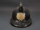 an old fireman ' s helmet with a gold emblem on it