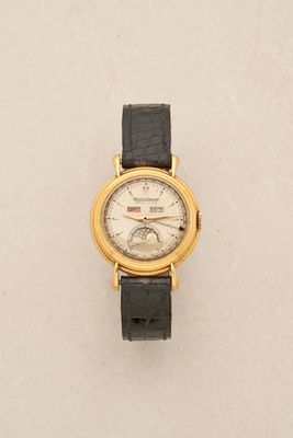 a close up of a watch on a white surface