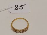 une bague en or et une étiquette posées sur une table blanche