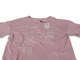 Le t-shirt est rose, avec des fleurs blanches dessus.
