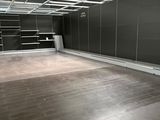 a large empty room with a wooden floor and black walls