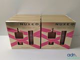two boxes of nuxe cosmetics on a table with a white background